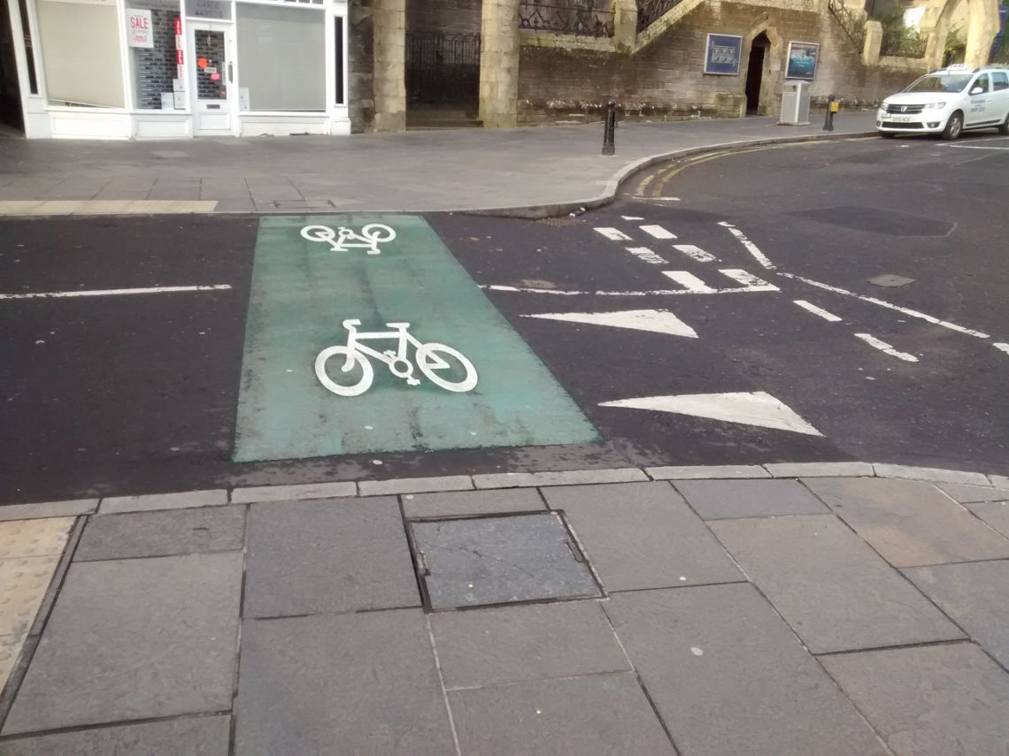 Image shows a confused situation where a green stripe is placed on the top of a speed hump, with a bicycle symbol drawn on it.
